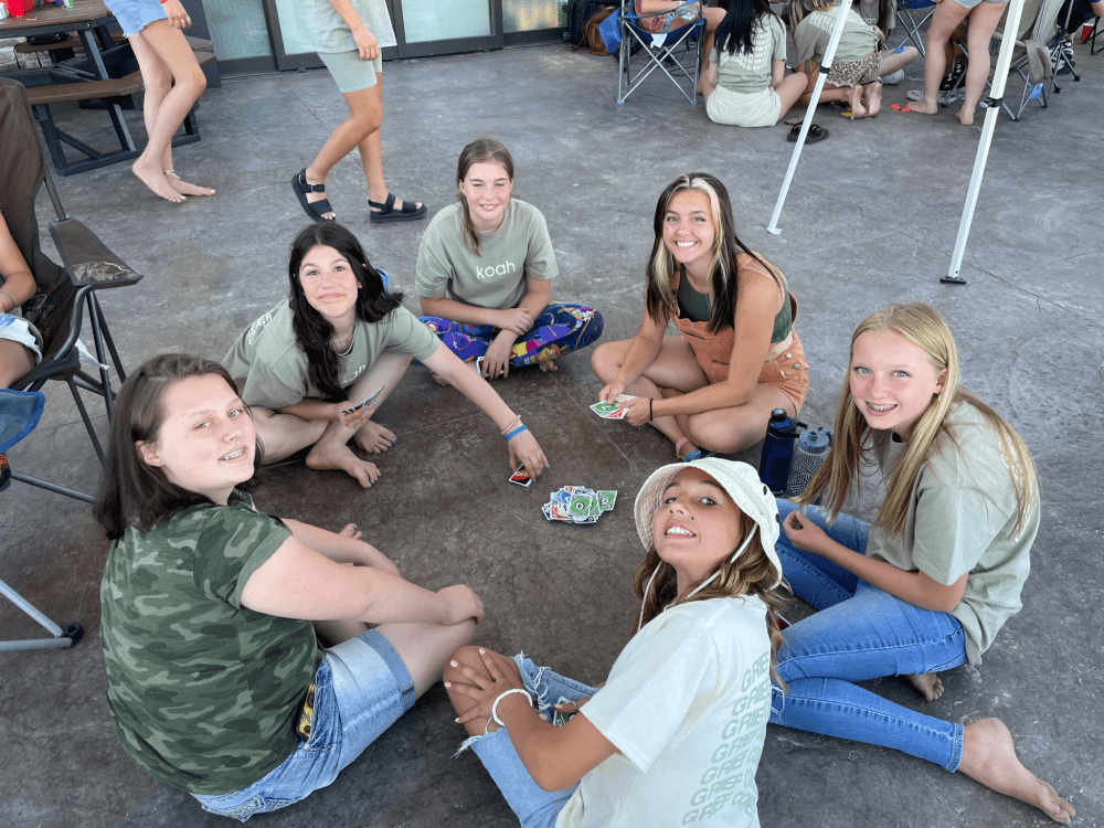 Campers sitting in a circle, playing a game.